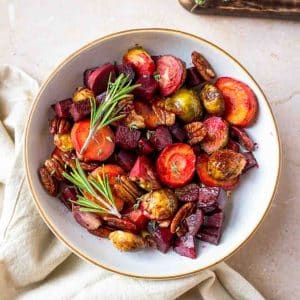 Roasted carrots, beets, and Brussels sprouts with pecans in a serving dish. Hostess At Heart