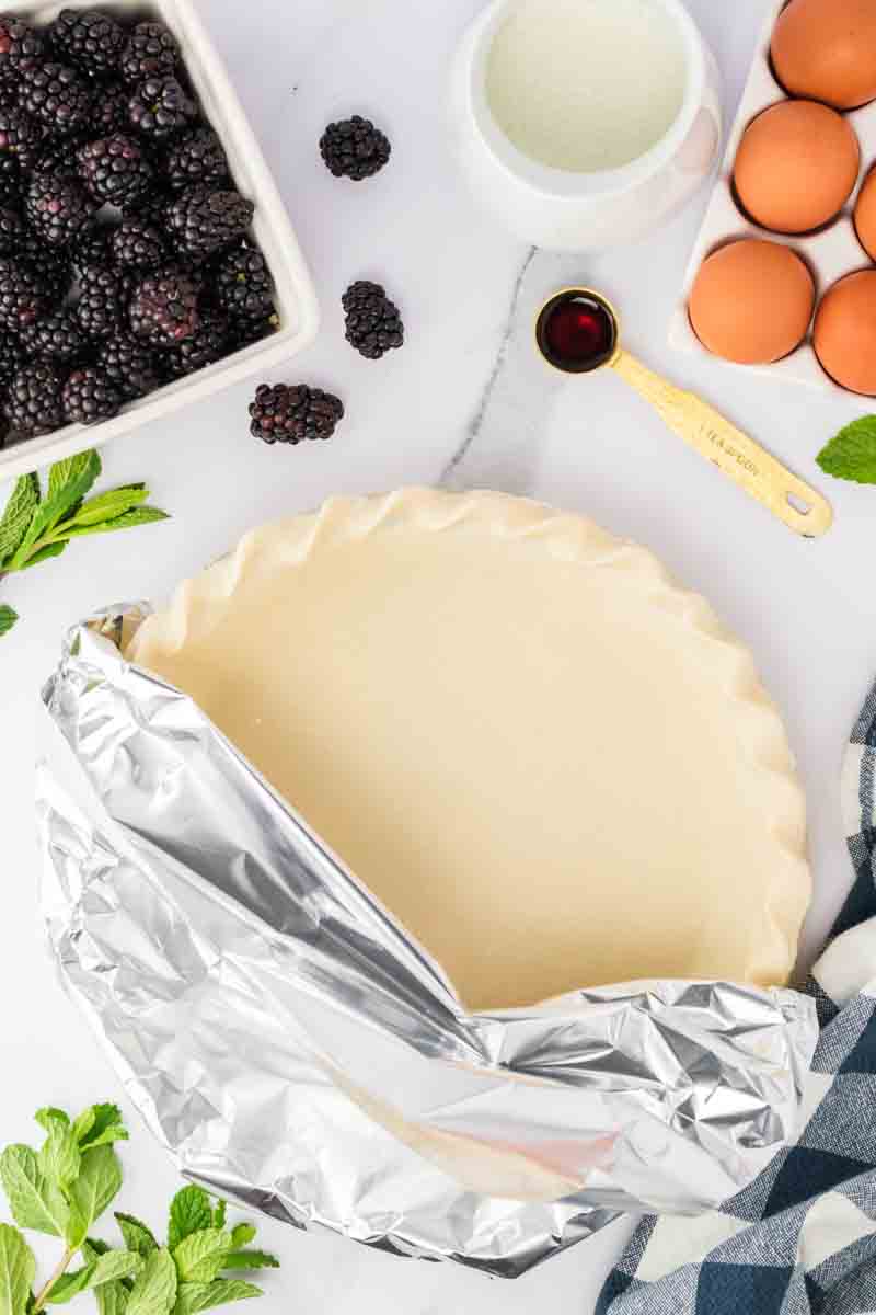 Pie crust partially covered with foil before par-baking. Hostess At Heart