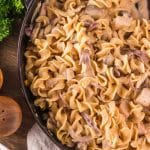 Top down view of a cast-iron skillet filled with creamy turkey stroganoff with mushrooms and egg noodles. Hostess At Heart
