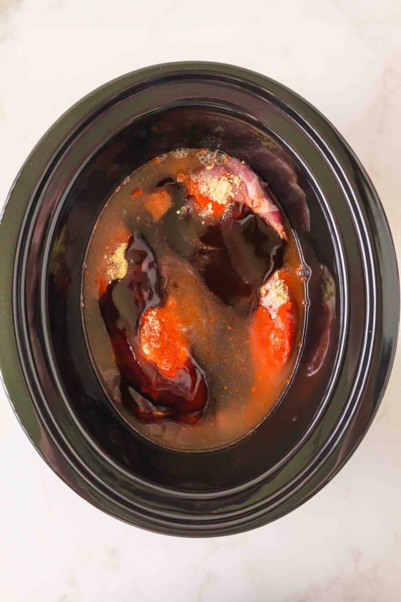 Pork tenderloin covered with spices, chicken broth, and BBQ sauce before cooking. Hostess At Heart