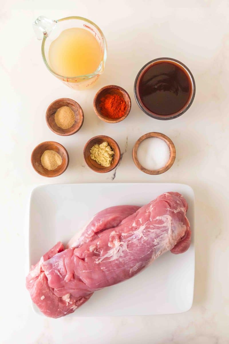Slow cooker pulled pork tenderloin recipe ingredients including pork tenderoins, chicken broth, BBQ sauce, and spices. Hostess At Heart